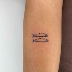 two fish tattoo on the arm