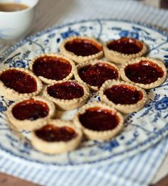 small pastries on a blue and white plate next to a cup of coffee