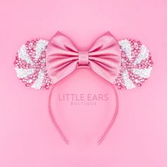 a pink minnie mouse ears headband with sequins and bows on it's side