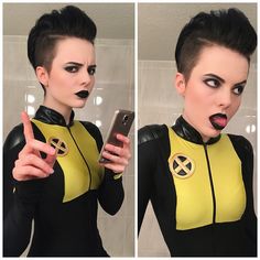 a woman dressed in black and yellow holding a cell phone with her finger up to the camera