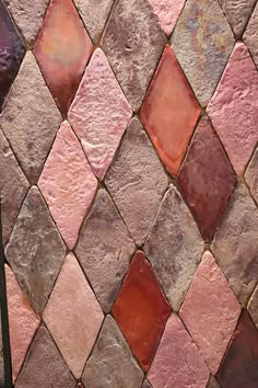 a close up view of a red and pink tile wall