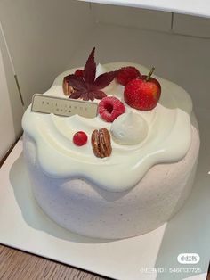 a cake with white frosting and fruit on top