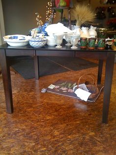 a table with plates and bowls on it in a room filled with other items that are sitting on the floor