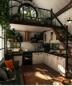 an open concept kitchen and living room with stairs leading to the upper floor, which also has a spiral staircase