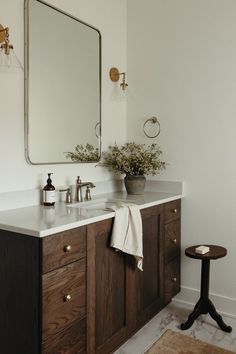 a bathroom with a sink, mirror and stool