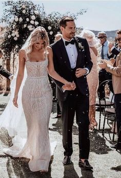 a bride and groom walk down the aisle as confetti is thrown around them