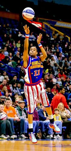 a basketball player jumping up to dunk the ball in front of an arena full of people