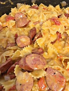 a pan filled with pasta and sausages on top of it's stovetop