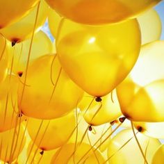 many yellow balloons are floating in the air