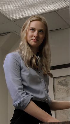 a woman standing next to a wooden table