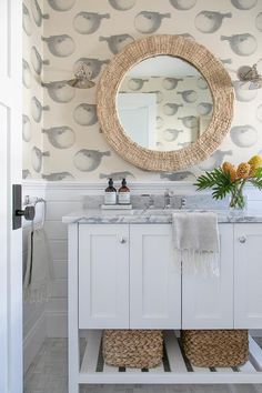 the bathroom is decorated in white and has a large round mirror above it, along with two sinks