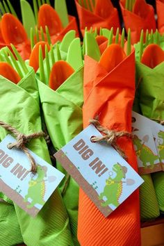 carrots wrapped in green and orange paper with tags on them