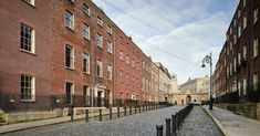 an empty cobblestone street lined with brick buildings