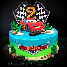 the birthday cake is decorated with cars 2 and has an image of a race car on it