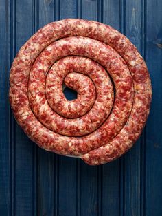 a large piece of sausage sitting on top of a blue surface