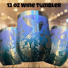 three blue vases sitting on top of a wooden table with flowers and birds painted on them