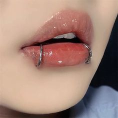 a woman's lips are covered with shiny liquid and metal ring around the lip