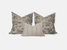 two decorative pillows on white background with blue and grey floral print, one is made from linen