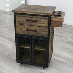 a wooden cabinet with two drawers on wheels