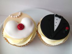 two cupcakes are decorated with white frosting and a black tuxedo