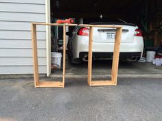 two wooden frames sitting in front of a white car