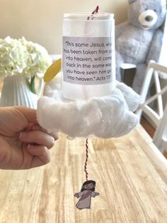 someone is holding up a candle that has been made to look like a cloud with an angel on it