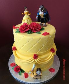 the cake is decorated with beauty and the beast figurines on top of it