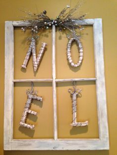 an old window frame is decorated with letters and branches to spell out the word love