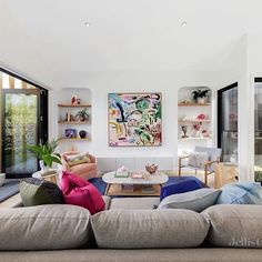 a living room filled with furniture and lots of windows