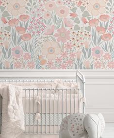 a baby crib in front of a floral wallpaper