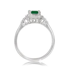 A geometric gemstone and diamond ring that features a lively natural emerald with a green saturation. Surrounding the center diamond is a halo of baguette-cut diamonds and round-cut diamonds. Additional baguette-cut diamonds are set on the shoulder. This ring is handcrafted in 14k white gold.
The approximate emerald weight of this ring is 0.79 carats. The total approximate diamond weight of this ring is 0.54 carats.
The measurements of this ring including the halo are approximately 9.60mm x 8.35 Art Deco Emerald Ring With Baguette Cut Center Stone, Art Deco Green Emerald Cut Diamond Ring, Green Emerald-cut Art Deco Diamond Ring, Classic Green Emerald Ring With Baguette Diamonds, Art Deco Baguette Cut Emerald Ring, Classic Green Diamond Ring With Baguette Diamonds, Green Emerald Ring With Halo Setting, Baguette Cut, Green Baguette Cut Emerald Ring With Halo Setting, Green Emerald Cut Emerald Ring With Baguette Diamonds