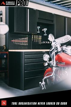 a red motorcycle is parked in front of a black cabinet with tools on it and the words tool organization never looked so good