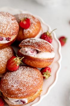 strawberry cream filled donuts on a plate with strawberries