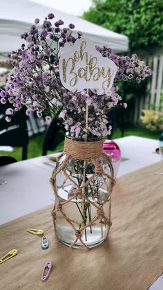 a mason jar filled with purple flowers sitting on top of a table