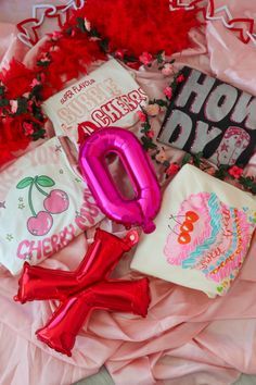 some pink and red items are laying on a bed