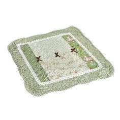 a green and white quilted placemat with two birds on the border, sitting on a white surface