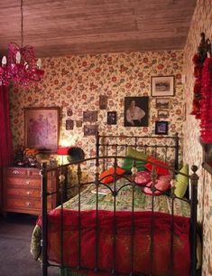 a bed room with a neatly made bed and red curtains