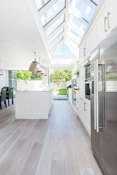 an open kitchen with white cabinets and stainless steel appliances, is seen in this image