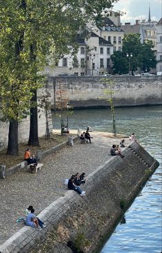 people sitting on the edge of a body of water