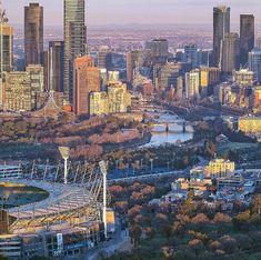 an aerial view of the city skyline with tall buildings in the foreground and a river running through it