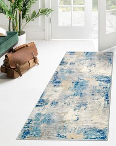 an area rug with blue and yellow colors on the floor in front of a door