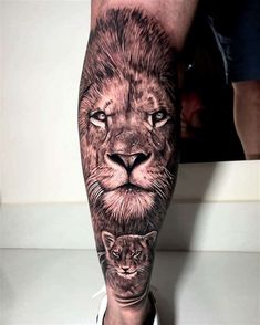 a man's leg with a lion and cat tattoo on it