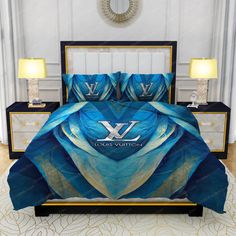 a bed with blue and white comforter set on top of it in a room