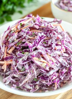 red cabbage slaw in a white bowl on top of a wooden cutting board with text overlay