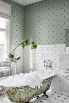 a bath tub filled with foam next to a window