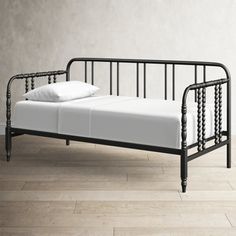 a black metal day bed with white pillows