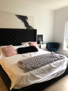 a bedroom with a large bed and black headboard