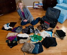 a woman is sitting on the floor surrounded by clothes and other items in her home