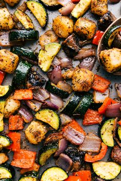 roasted vegetables on a baking sheet with a wooden spoon