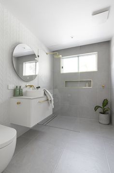 a bathroom with a sink, toilet and shower stall in the middle of it's walls